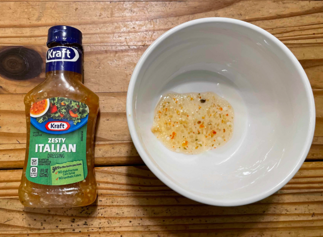 a bottle of kraft italian dressing with some in a bowl.