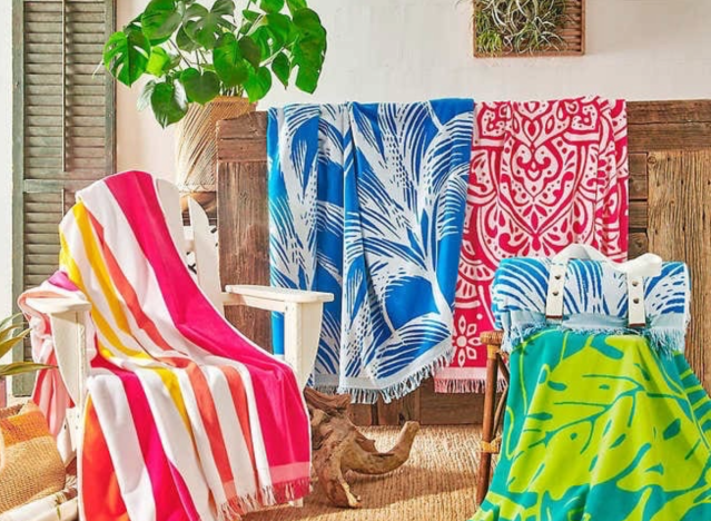 assorted colorful beach towels draped over chairs.
