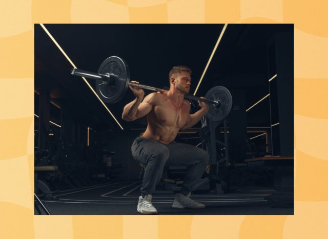 fit, muscular man doing barbell back squats in dark gym