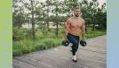 muscular, shirtless man doing dumbbell lunges outside on boardwalk surrounded by foliage