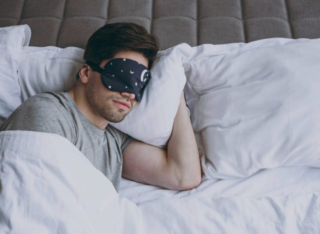 man with sleep mask resting in bed