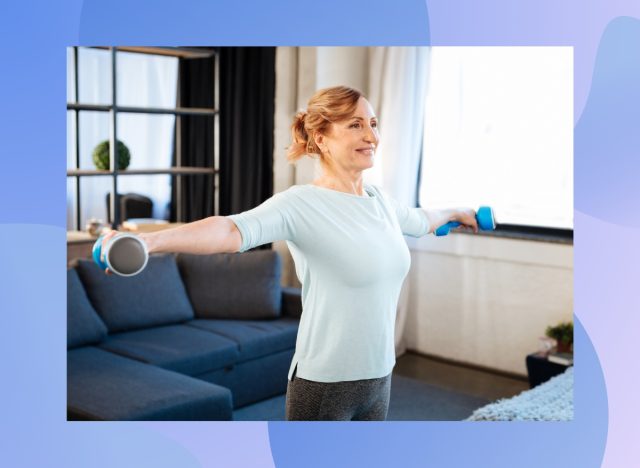 mature, happy woman lifting dumbbells while exercising in her living room