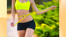 fit woman close-up measuring waistline outside