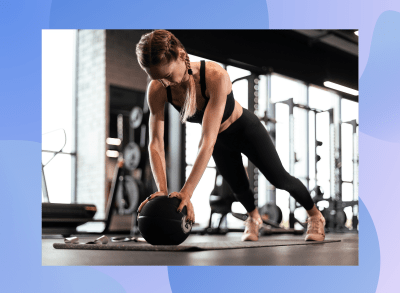 fit blonde woman with braids doing medicine ball pushups at the gym