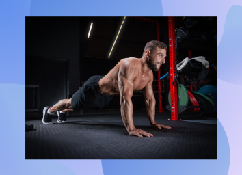 muscular man doing pushups in dark gym