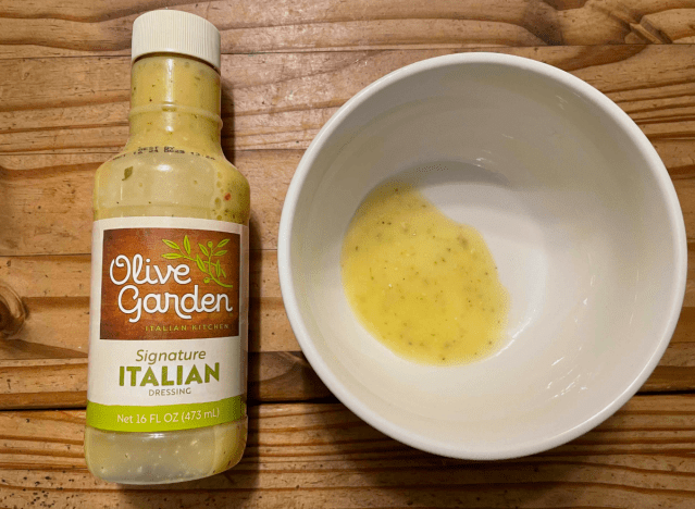 olive garden dressing in a bottle with bowl beside it.