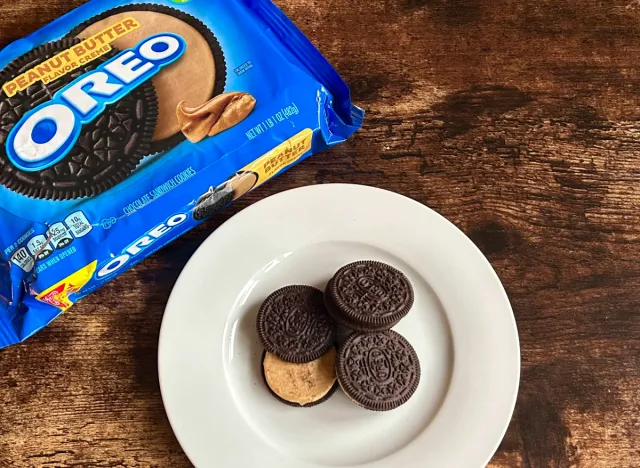 peanut butter oreos on a plate next to a package of peanit butter flavor oreos