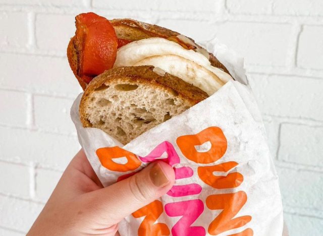 person holding dunkin' sourdough breakfast sandwich