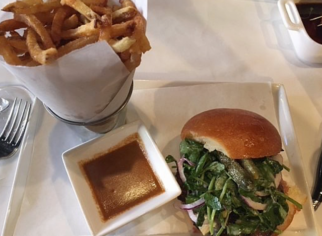 a burger from raoul's and fries on a platter.