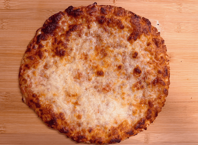 a gluten free cheese pizza on a cutting board. 