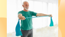 happy senior man doing resistance band exercise in bright workout room