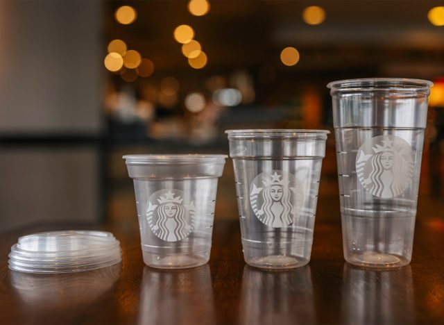 starbucks tall, grande, and venti plastic cups and lid on a wooden table