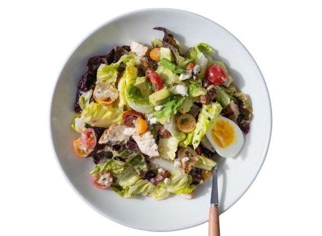 tender greens' grilled chicken cobb salad in a white bowl with a fork in it