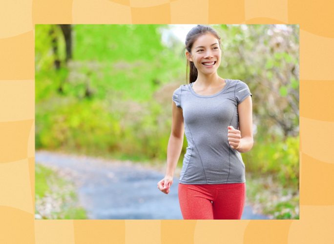 happy woman walking for exercise outdoors on lush, green trail