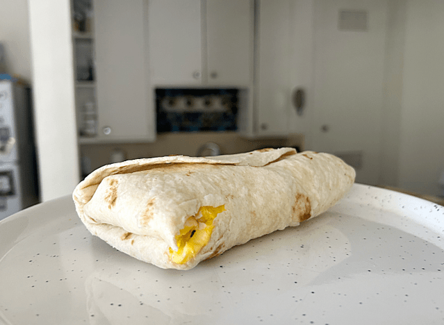 wendys breakfast burrito on a white plate in a kitchen.