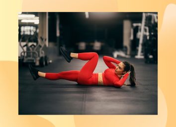 fit woman in red athletic attire doing bicycle crunches at the gym