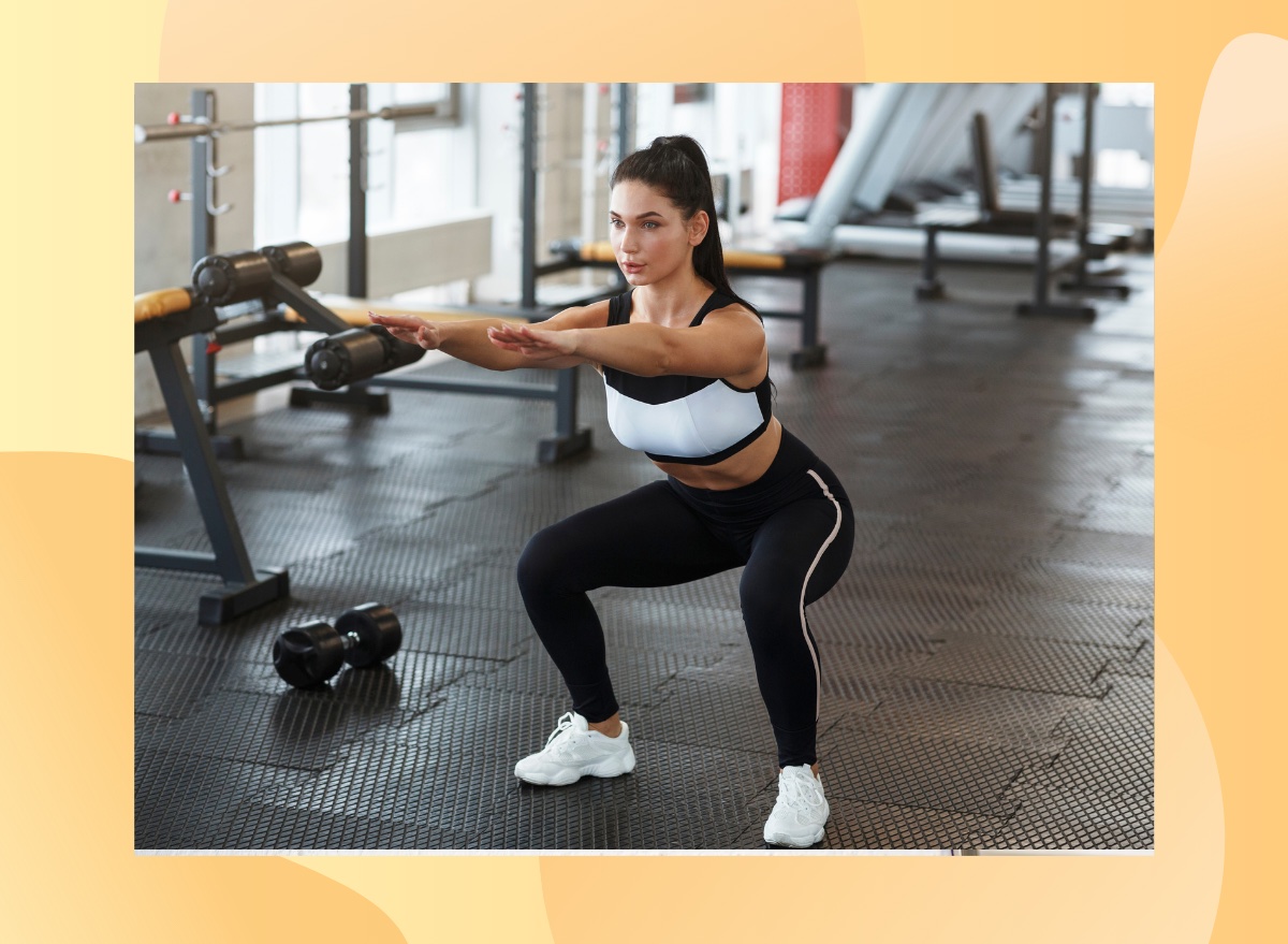 fit woman at the gym wearing black and white athletic attire doing squats