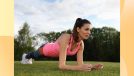 fit brunette woman wearing pink tank, leggings, and white sneakers doing forearm plank exercise in park