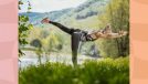 fit blonde woman doing yoga, warrior III pose in a grassy meadow by a lake