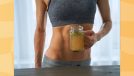 close-up of fit woman holding a mug of bone broth in kitchen