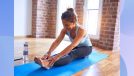 senior woman doing forward fold exercise on a yoga mat