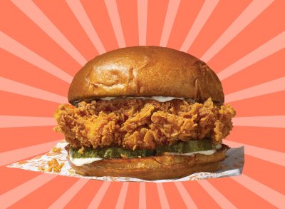 Popeyes fried chicken sandwich set against a colorful background