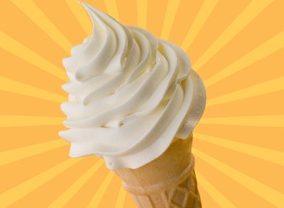 A vanilla soft serve ice cream cone set against a colorful background