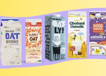 An array of different brands of non-dairy oat milk set against a colorful background