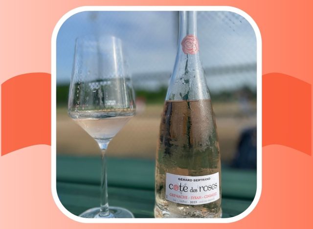 A bottle of Cote de Roses next to a glass of the pink-tinted wine.