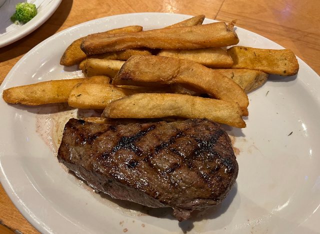 Hand-cut sirloin steak with fries on a white plate at Texas Roadhouse