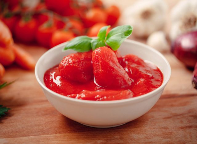 canned tomatoes in white bowl on wooden table