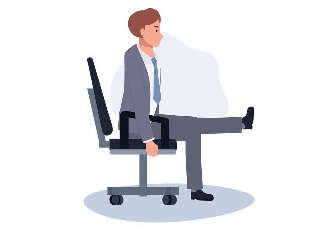 Man sitting in a chair with one leg extended, one leg on the ground. 