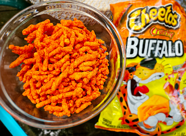 crunchy buffalo cheetos in a bowl next to a bag.