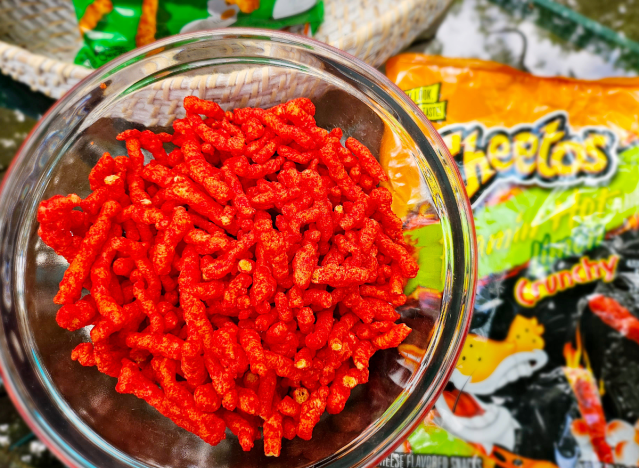 a bowl of limon cheetos next to a bag.