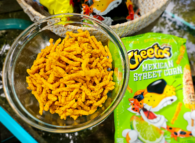 a bowl of mexican street corn cheetos next to a bag.