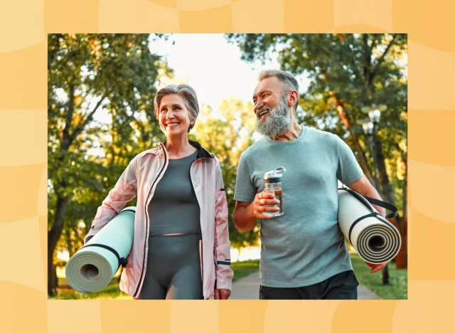 mature couple holding yoga mats walking to fitness class outdoors