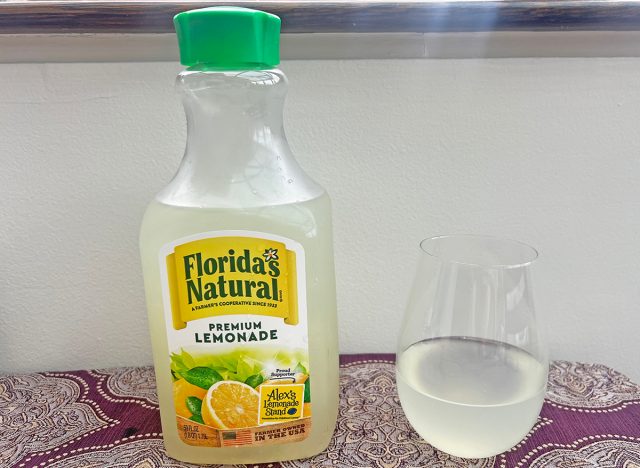 A bottle of Florida's Natural brand lemonade next to a small glass of the beverage