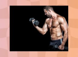 muscular, shirtless man doing bicep curls in front of black backdrop