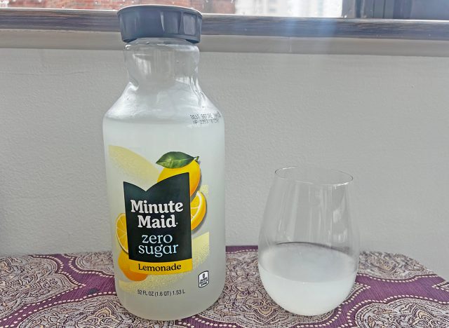 A bottle of Minute Maid Zero Sugar lemonade next to a small glass of the beverage