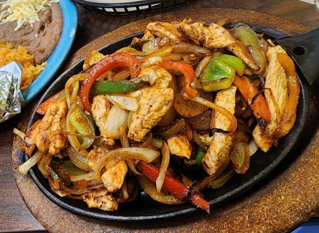 plate of chicken fajitas with peppers and onions