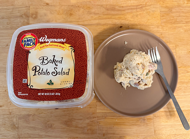a container of wegman's baked potato salad next to a dish of potato salad