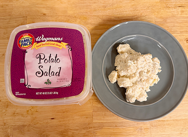 a container of wegmans potato salad next to a dish of potato salad