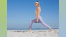 focused blonde woman doing dumbbell workout on beach on clear, sunny day