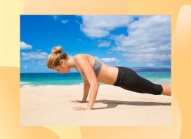 fit woman in sports bra and leggings doing pushups on sand at the beach by turquoise ocean water