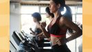 fit brunette woman running on treadmill at gym in line of treadmills