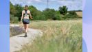 brunette woman walking outdoors on trail
