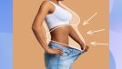 woman holding big pair of jeans out from waist, concept of fat loss and weight loss