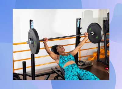 woman doing barbell bench press at the gym