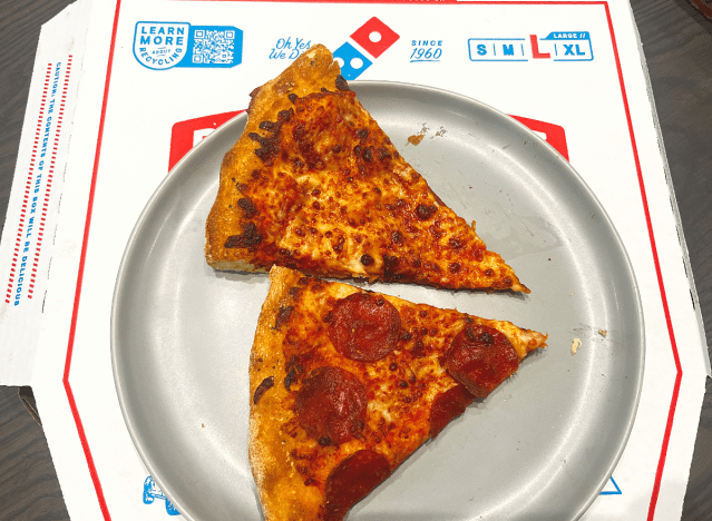 two slices of dominos pizza on top of a box