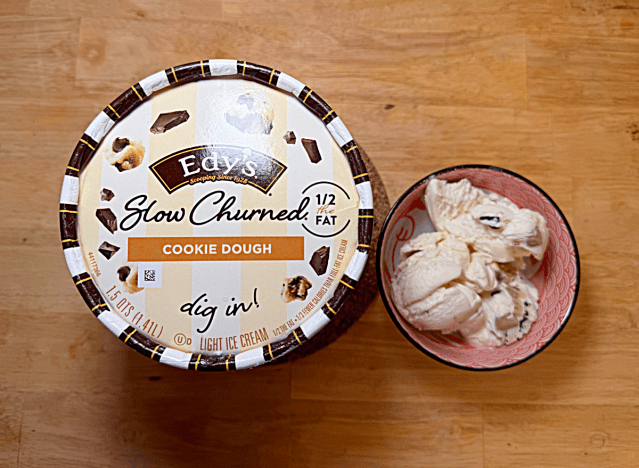 a container of edys slow churned cookie dough with a bowl of it 